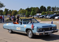 Blue car with Shriners decals and American flag